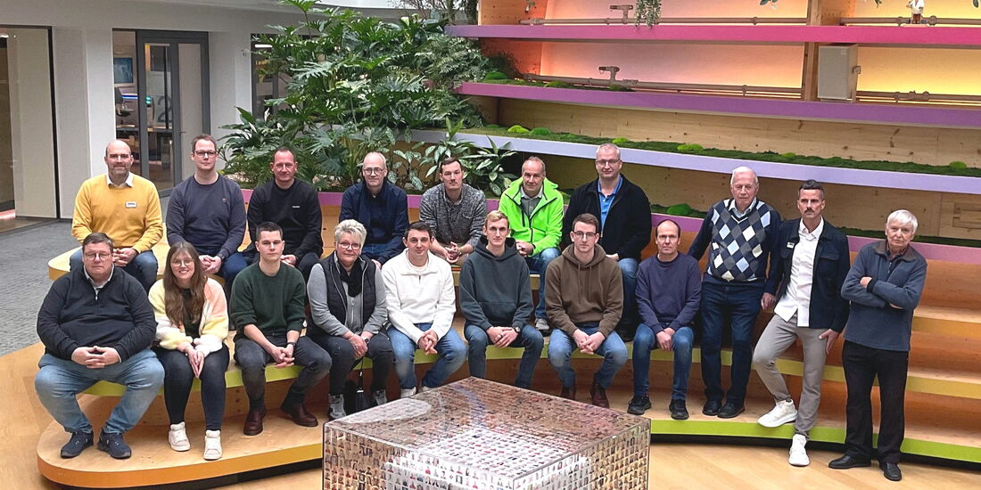 Gruppenfoto der Innungsmitglieder auf Bänken im Foyer von Brillux in Münster.