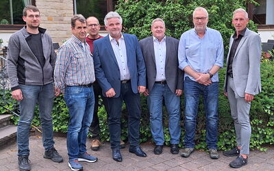 Vorstandsmitglieder der Tischler-Innung Waldeck-Frankenberg stehen gemeinsam im Freien und blicken in die Kamera.