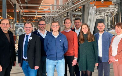 Gruppenfoto bei Finger-Haus: Vertreter von Arbeitsagentur, IHK, Kreishandwerkerschaft und Ausbildern stehen zusammen.