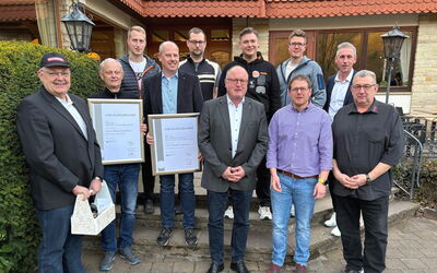Guido Kalbe (Mitte) und André Landskron (2. v. r.) stehen nebeneinander. Das Foto zeigt den offiziellen Wechsel des Obermeister-Amts.